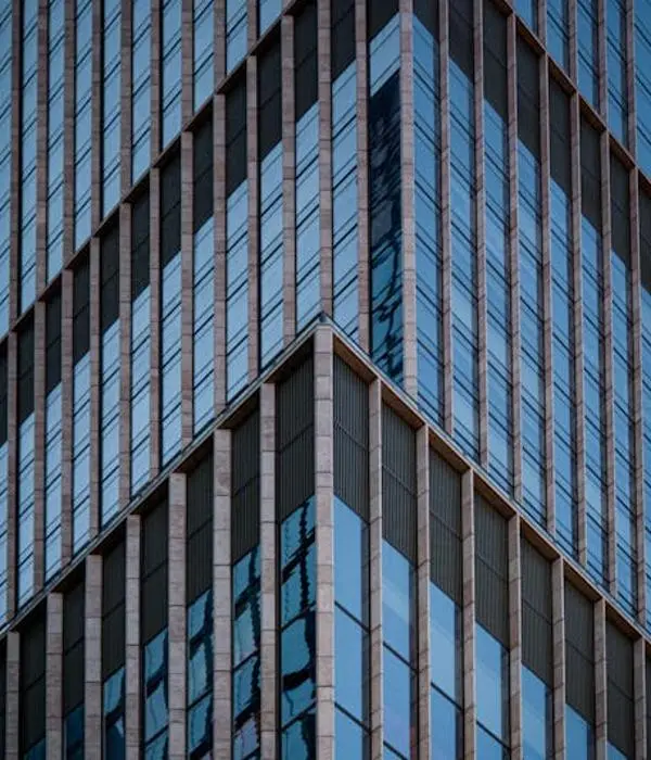 Nowoczesny szklany wieżowiec z fasadą aluminiowo-szklaną – przykład zastosowania stolarki aluminiowej w budownictwie.