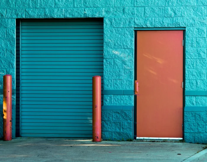 Zewnętrzne drzwi aluminiowe w budynku przemysłowym – przykład nowoczesnej stolarki.